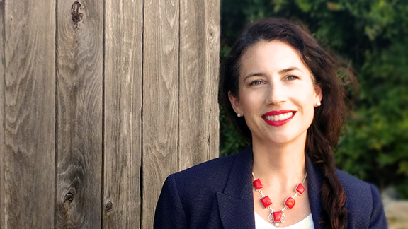 Headshot of Juel Lugo against a rustic wooden fence