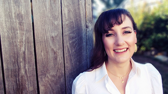 Headshot of Bethany Maines against a rustic wooden fence